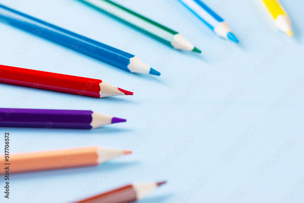 Colored pencils in a semicircle on a blue background. Colored pencils in a semicircle on a blue background.