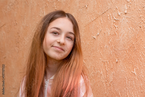 Girl 11 years old on a background of beige wall. Teen girl portrait.