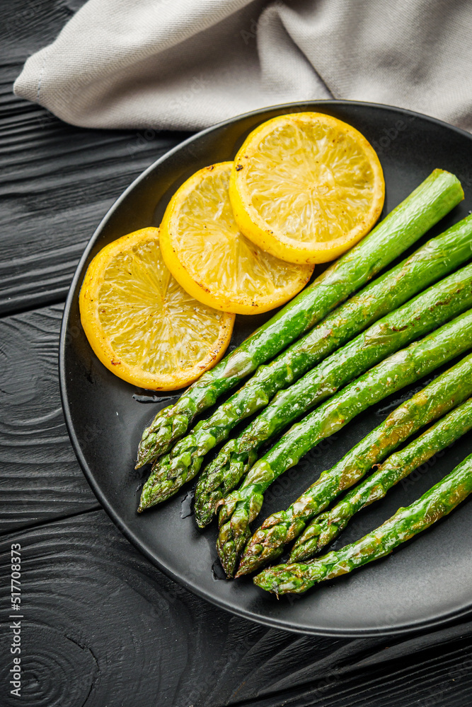 roasted green asparagus on a black wooden rustic background roasted green asparagus on a black wooden rustic background