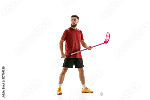 Portrait of young man, floorball player with floorball stick isolated on white background. Sport, competition and motion, movement, active lifestyle photo