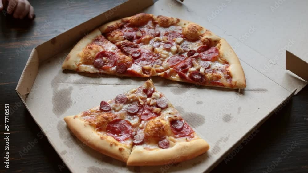 Top view of children's and female hands take slices of pizza with cheese, tomato sauce. Pizza restaurant. Many hands take pizza from a cardboard box. Full HD Top view of children's and female hands take slices of pizza with cheese, tomato sauce. Pizza restaurant. Many hands take pizza from a cardboard box. Full HD