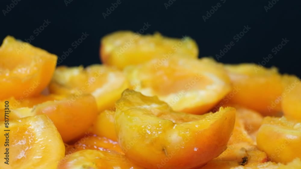 Juicy apricot slices on a black background, side view. Juicy apricot slices on a black background, side view.