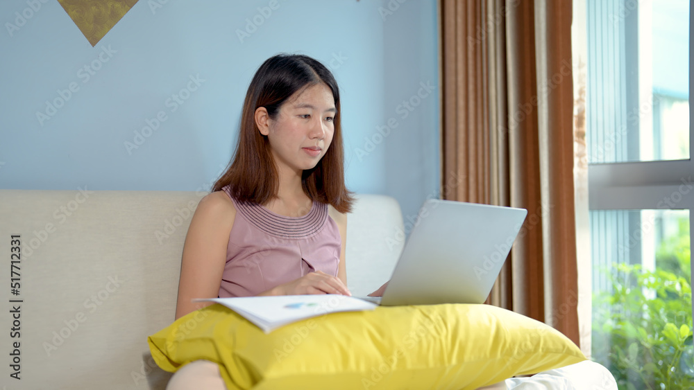 Asian teen girl on video call with classmates in bed with the computer in front of you to discuss your studies. woman sits in a hotel room using a laptop on vacation. work from anywhere Asian teen girl on video call with classmates in bed with the computer in front of you to discuss your studies. woman sits in a hotel room using a laptop on vacation. work from anywhere