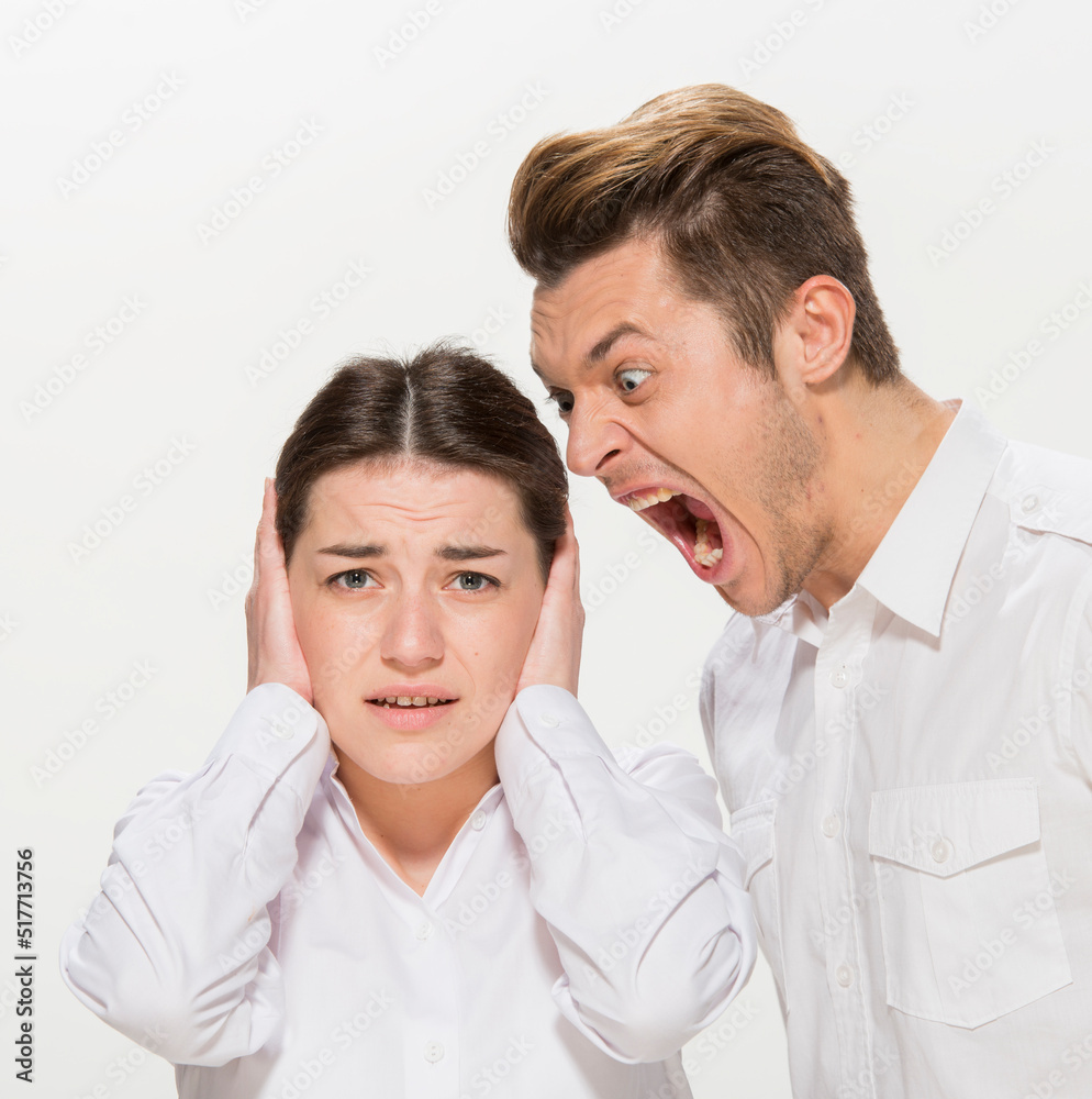 the boss scolds the young subordinate.close-up portrait of two workers on a white background isolated.the man yells at the girl.teaches the girl.points out the mistakes. the boss scolds the young subordinate.close-up portrait of two workers on a white background isolated.the man yells at the girl.teaches the girl.points out the mistakes.