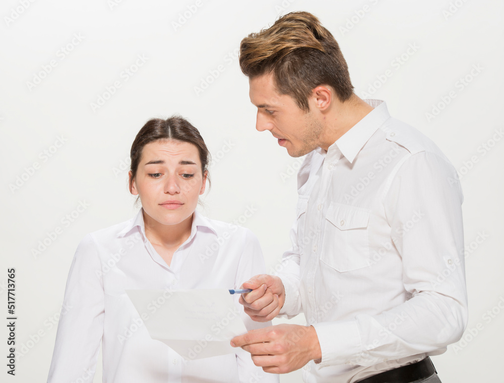 the boss scolds the young subordinate.close-up portrait of two workers on a white background isolated.the man yells at the girl.teaches the girl.points out the mistakes. the boss scolds the young subordinate.close-up portrait of two workers on a white background isolated.the man yells at the girl.teaches the girl.points out the mistakes.