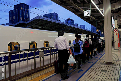 夕暮れの東京駅で東海道新幹線に乗り込む乗客