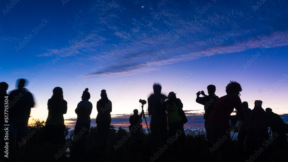 Fototapeta premium Silhouette group of people enjoying sunrise new year camping on mountain