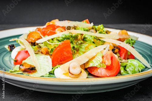 fresh tasty salad with seafood on a black background