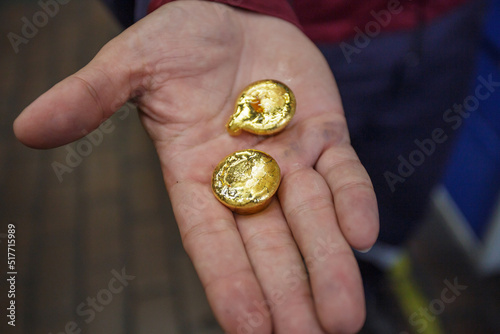 Man holds samples of gold metal.