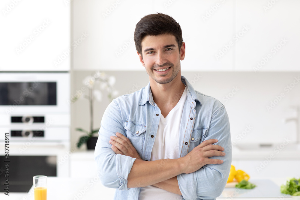 Smiling man arms crossed in the kitchen. Male lifestyle portrait Smiling man arms crossed in the kitchen. Male lifestyle portrait