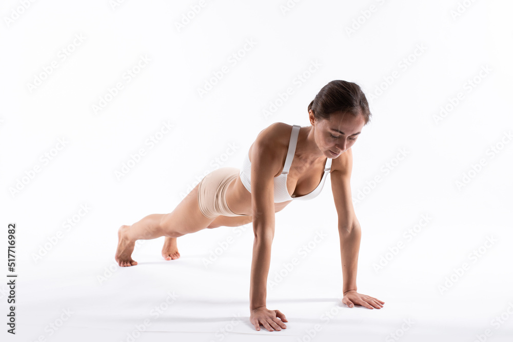 Beautiful fitness woman doing push-ups isolated on white. Beautiful fitness woman doing push-ups isolated on white.
