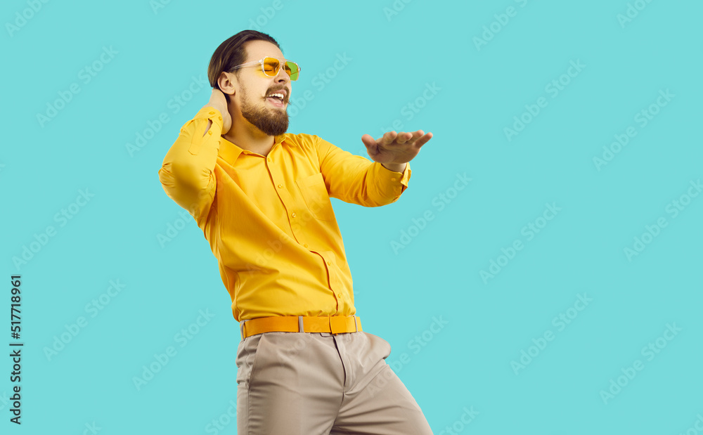 Cheerful cool stylish man partygoer having fun and dancing isolated on light blue background. Caucasian bearded male clubber in casual outfit singing along to dancing at party. Web banner. Cheerful cool stylish man partygoer having fun and dancing isolated on light blue background. Caucasian bearded male clubber in casual outfit singing along to dancing at party. Web banner.