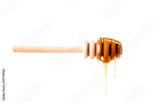 Honey dripping from a wooden dipper on white background