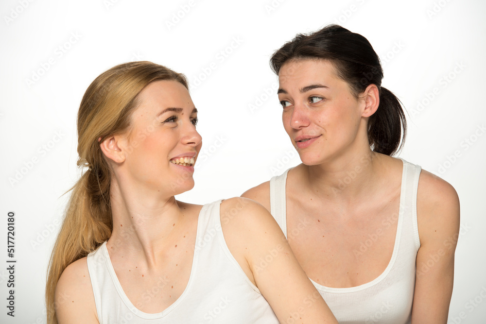 beauty portrait of two young attractive blonde and brunette girls on a light background isolated beauty portrait of two young attractive blonde and brunette girls on a light background isolated