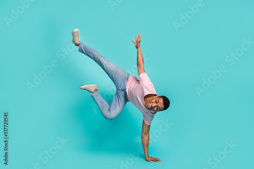 Full length photo of cheerful funny man dressed pink t-shirt dancing standing hands arms isolated turquoise color background