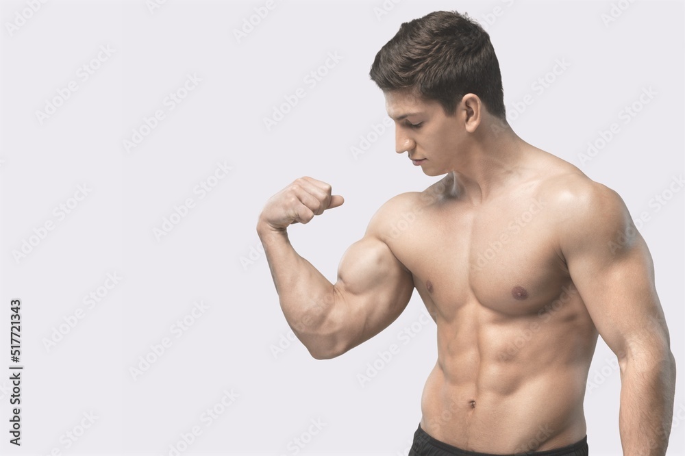 Workout and gym concept. Handsome man showing his muscles after sport exercises, flexing biceps Workout and gym concept. Handsome man showing his muscles after sport exercises, flexing biceps