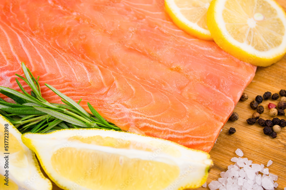 Salmon fillet with lemon and rosemary on a wooden board. Salmon fillet with lemon and rosemary on a wooden board.