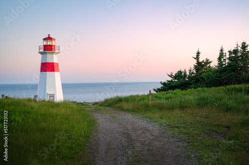 The beautiful Musquash head lighthouse at dusk, that overlook the coast over bay of fundy, St-John, New Brunswick, Canada photo
