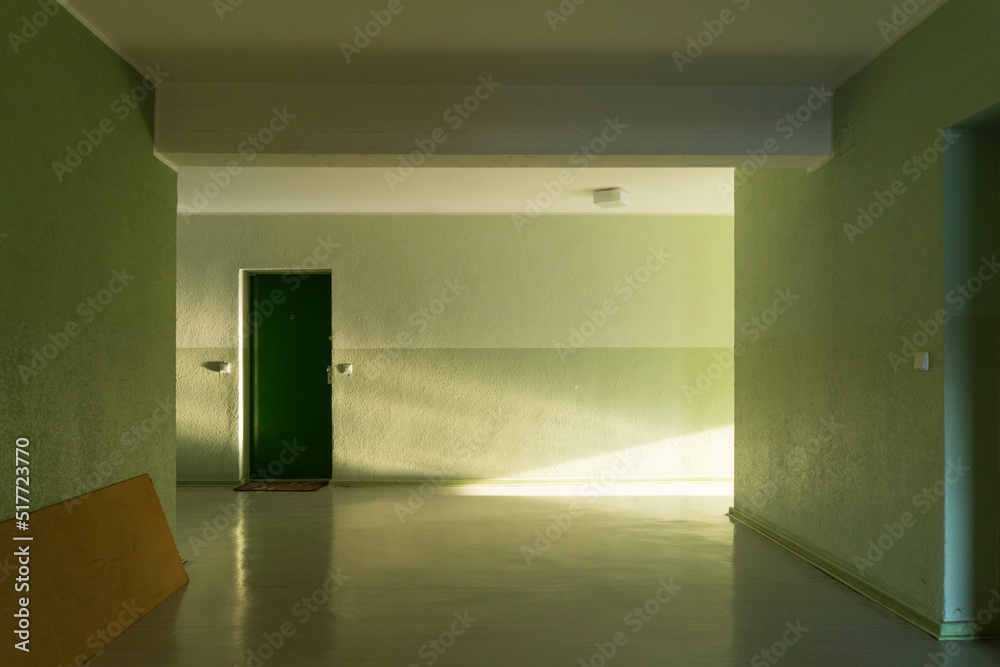 Early morning sunlight shines through window into green painted hallway of East Berlin Apartment block Early morning sunlight shines through window into green painted hallway of East Berlin Apartment block
