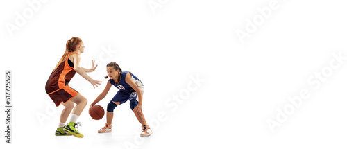Play defense. Two basketball players, young girls, teen training with basketball ball isolated on white background. Concept of sport, team, enegry, competition, skills © master1305