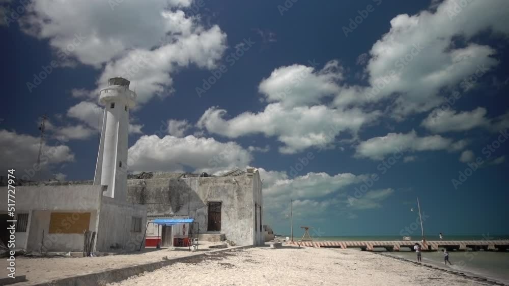 Lighthouse with fishing pier with a white sand beach and blue sky with clouds. Lighthouse with fishing pier with a white sand beach and blue sky with clouds.