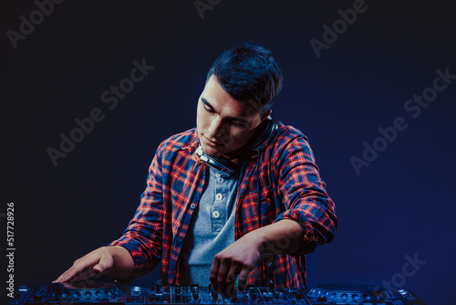 exicted dj sound device oprator with headphones by dancing at club - concept of entertainment, nightlife, music club and musician photo