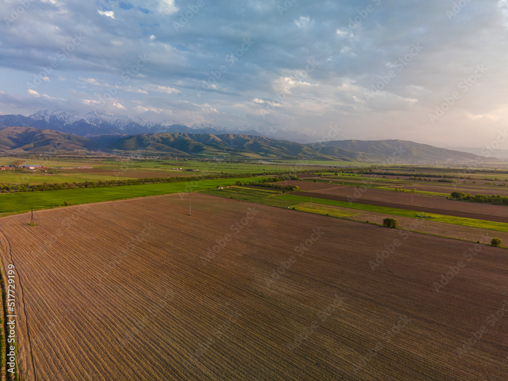 Fantastic landscape, aerial photography from a plowed field with mountains in the background. Issyk fields are not far from Almaty.