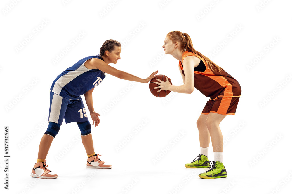 Two basketball players, young girls, teen playing basketball isolated on white background. Concept of sport, team, enegry, competition, skills Two basketball players, young girls, teen playing basketball isolated on white background. Concept of sport, team, enegry, competition, skills