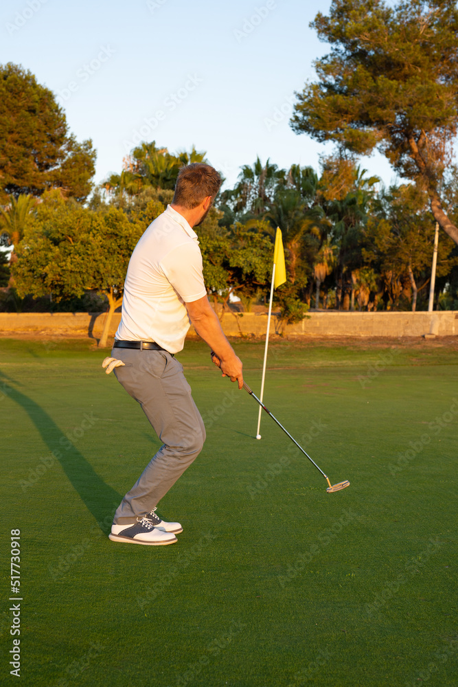 Fototapeta premium Golf ball on green grass ready to be struck at golf club, close up in golf course.