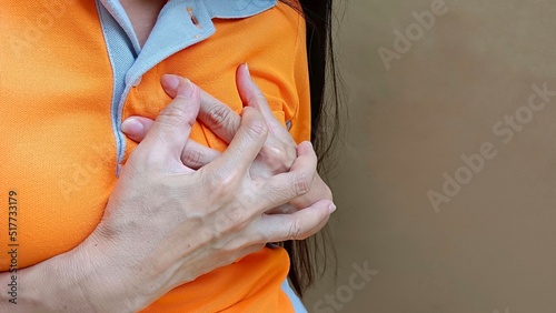 Woman's hand holding her chest. photo