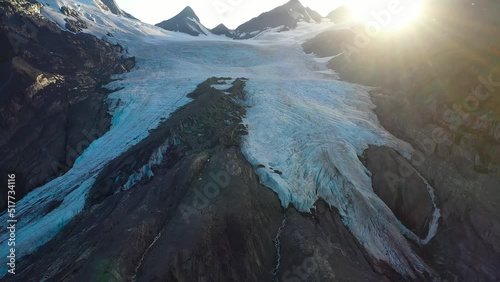 Melting snow on snowcapped mountain slope under sunlight in summer Alaska photo