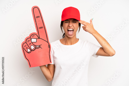 hispanic pretty woman looking unhappy and stressed, suicide gesture making gun sign. number one hand fan concept