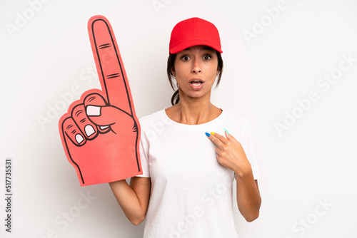 hispanic pretty woman looking shocked and surprised with mouth wide open, pointing to self. number one hand fan concept photo