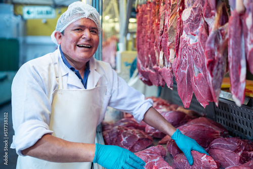 Male butcher near stall with meat photo