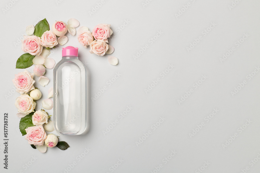 Micellar water with rose flower on color background, top view Micellar water with rose flower on color background, top view