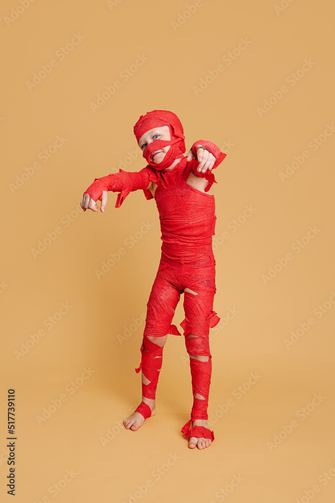 Funny child pretending being mummy during Halloween Funny child pretending being mummy during Halloween