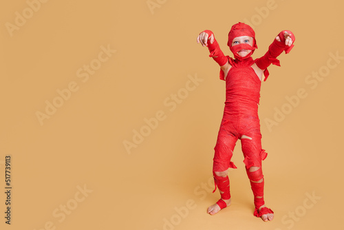 Funny child pretending being mummy during Halloween photo