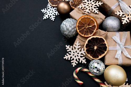 Beautiful Christmas golden silver decorations on a dark black background. Flat design, postcard, calendar, banner. Place for text.