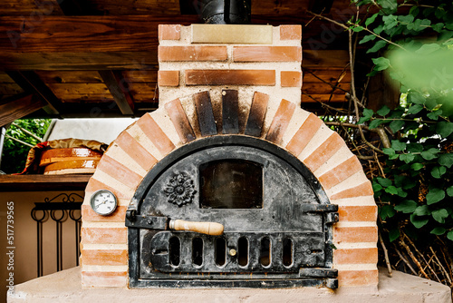 Small brick furnace with metal door in countryside