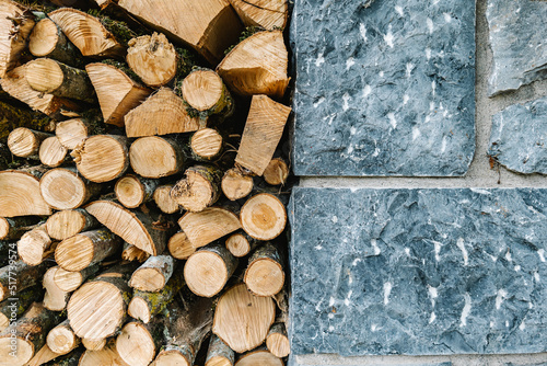 Stack of woodpile near stone wall in rural house