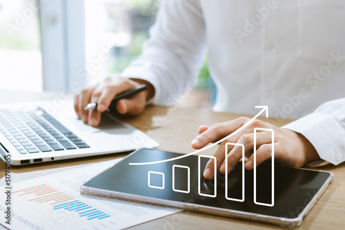 Businessman analyzing company's financial balance sheet working with digital augmented reality graphics. Businessman calculates financial data for long-term investment. photo