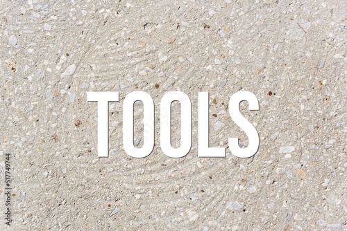 TOOLS - word on concrete background. Cement floor, wall.