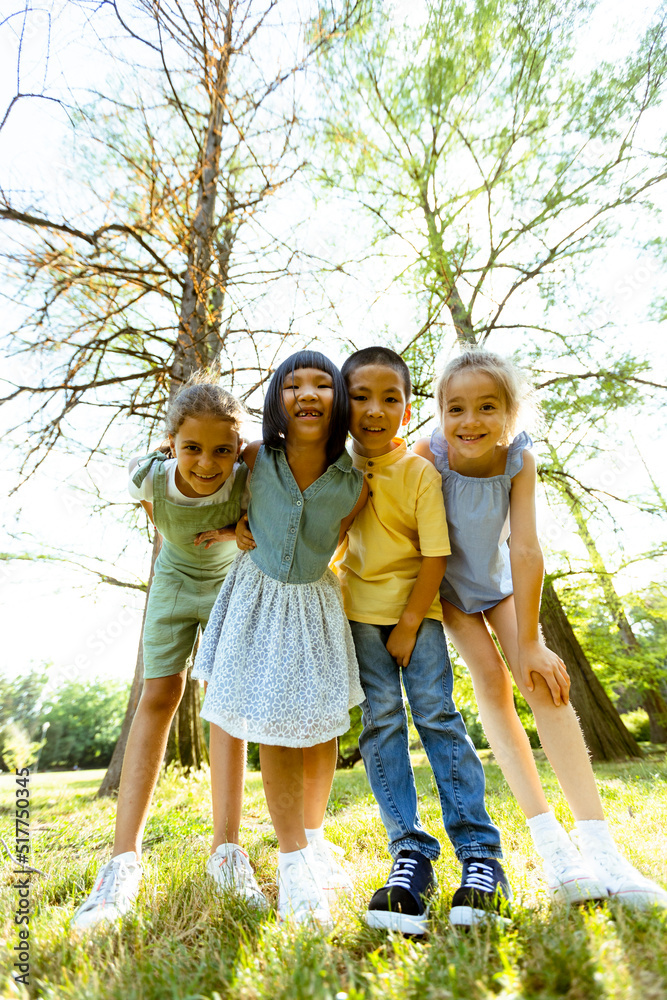 Fototapeta premium Group of asian and caucasian kids having fun in the park
