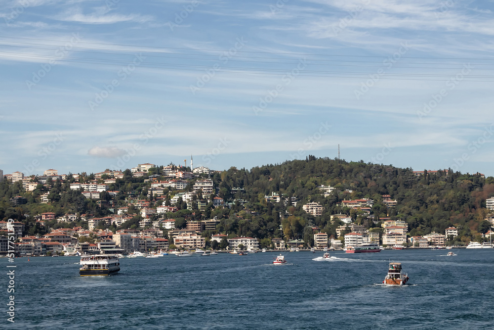 View of yachts and cruise tour boats on Bosphorus and Bebek neighborhood on European side of Istanbul. It is a sunny summer day. Beautiful travel scene. View of yachts and cruise tour boats on Bosphorus and Bebek neighborhood on European side of Istanbul. It is a sunny summer day. Beautiful travel scene.
