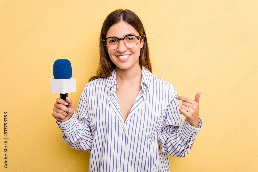 Young caucasian presenter TV woman isolated on yellow background person pointing by hand to a shirt copy space, proud and confident Young caucasian presenter TV woman isolated on yellow background person pointing by hand to a shirt copy space, proud and confident