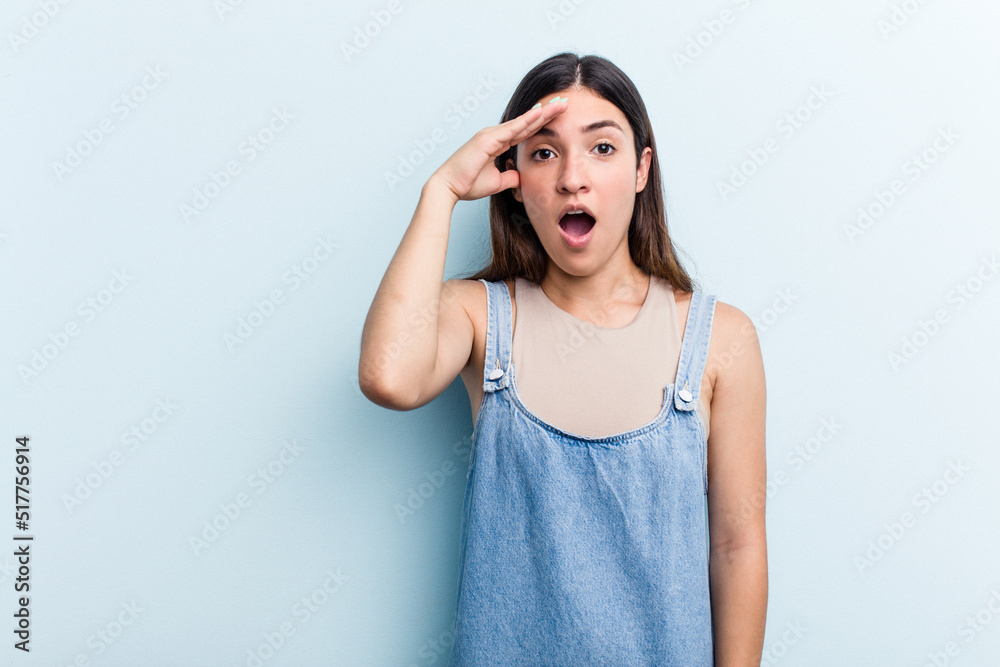 Young caucasian woman isolated on blue background shouts loud, keeps eyes opened and hands tense. Young caucasian woman isolated on blue background shouts loud, keeps eyes opened and hands tense.