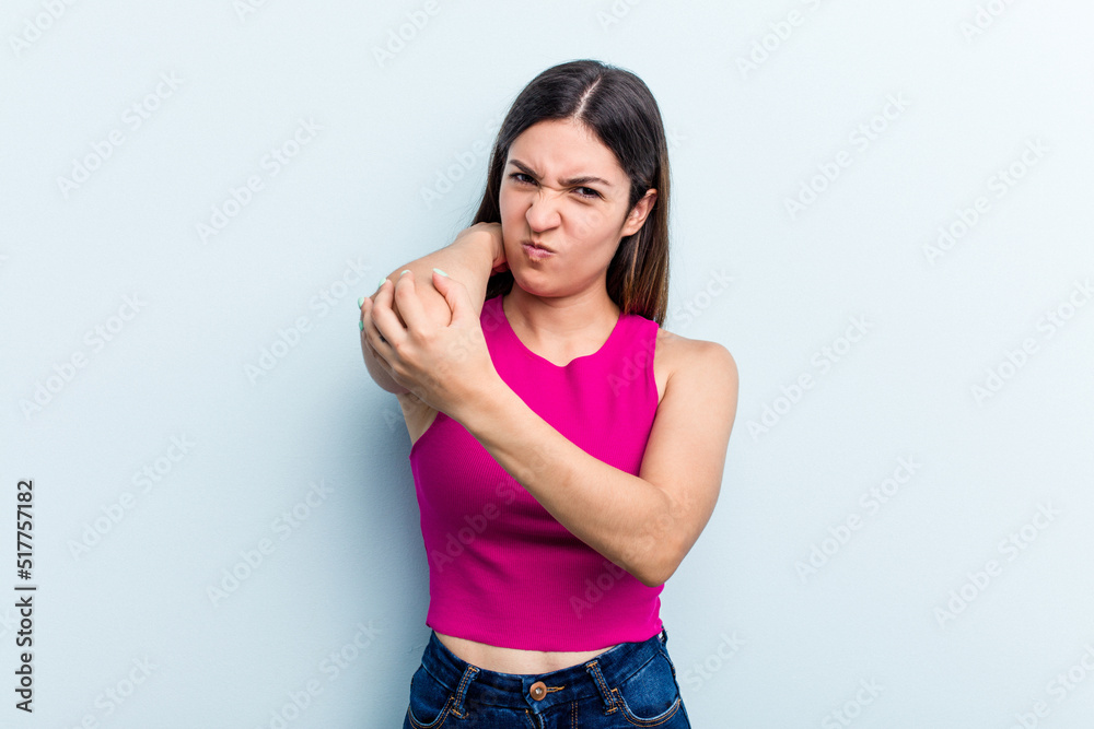 Young caucasian woman isolated on blue background having a neck pain due to stress, massaging and touching it with hand. Young caucasian woman isolated on blue background having a neck pain due to stress, massaging and touching it with hand.