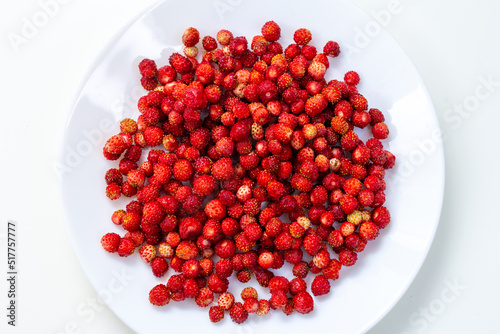 a bowl of wild strawberries close-up on a white background