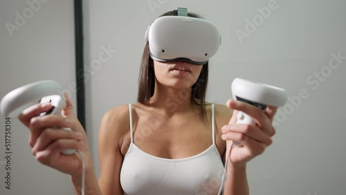 Excited slim young woman in VR headset and underwear gaming online standing indoors. front view portrait of absorbed seductive African American lady playing video game in augmented reality