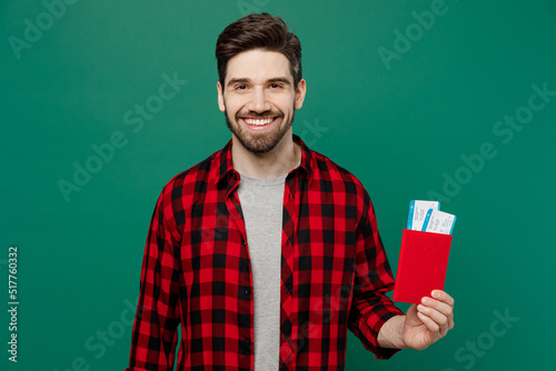 Traveler tourist fun man he wear casual clothes hold passport boarding tickets isolated on plain dark green background studio. Passenger travel abroad on weekends getaway. Air flight journey concept.